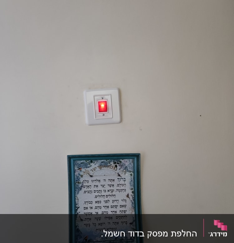 מתג דולק עם אור אדום על קיר לבן